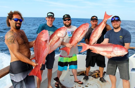 Black man rods deep sea snapper holds holding catch hi-res stock